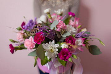 A womans hand is holding a bouquet of flowers