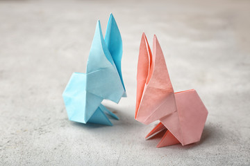Origami paper bunnies on light background