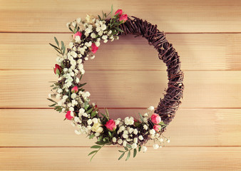 Floral wreath with beautiful flowers on wooden background