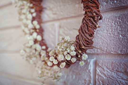 Floral wreath with beautiful flowers on white brick wall background