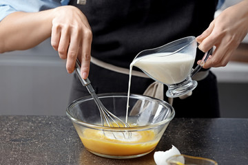 Young woman cooking in kitchen, closeup