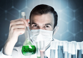 Portrait of concentrated male scientist working with reagents in laboratory