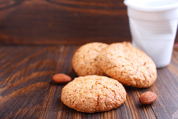 Almond cookie on a brown wooden background, the branches of spruce