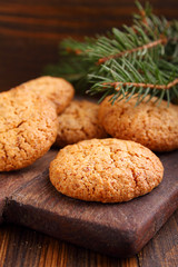 Almond cookie on a brown wooden background, the branches of spruce