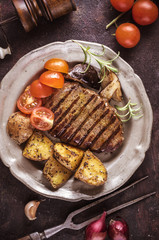 Grilled steak with sliced potato and tomatoes vertical
