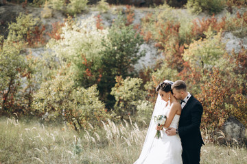 Stylish wedding couple posing outdoor