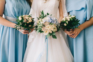 Wedding bride and your girlfriends in blue dress with bouquets