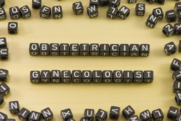 Obstetrician gynecologist phrase on a wooden background