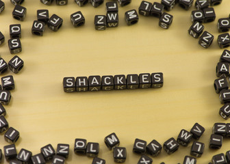 The word shackles on wood background - Powered by Adobe