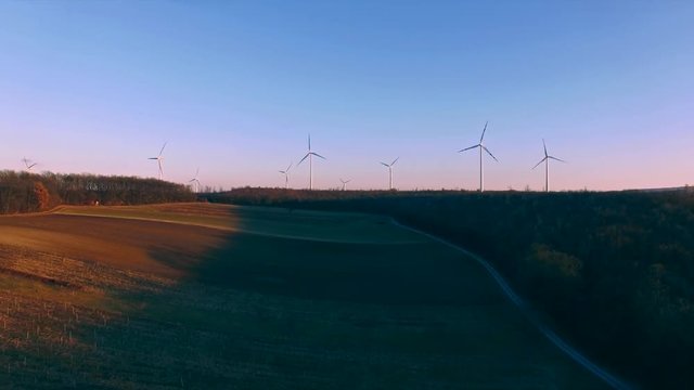 Wind turbines on field, filmed at susnet with a drone