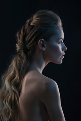 Fototapeta premium Fashion portrait of model in the light colored spotlights.