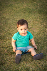 baby sitting on green grass