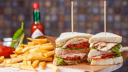 Delicious club sandwich with french fries at a diner. - obrazy, fototapety, plakaty