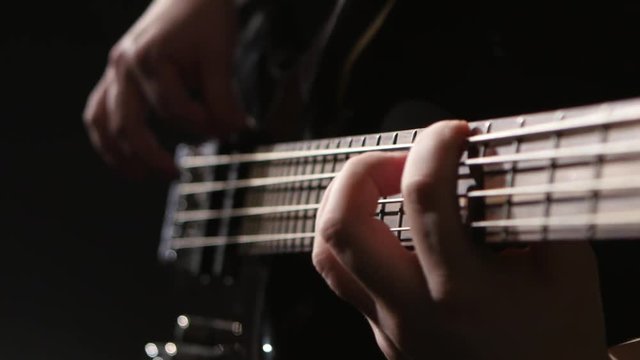 Close shot of the strings on a bass guitar
