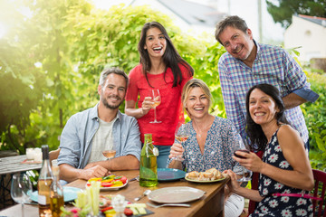 Group of friends gathered around a table on a summer terrace