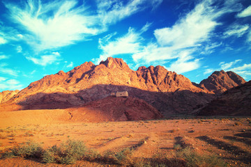 Fototapeta na wymiar House on hill in desert next to mountain. Beautiful landscape.