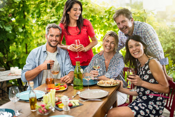 Group of friends gathered around a table on a summer terrace