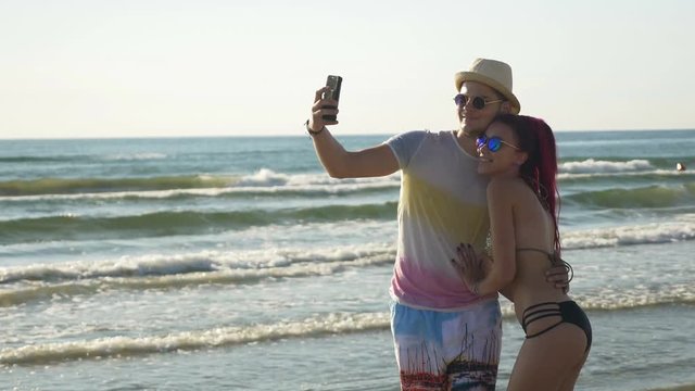 Happy young couple taking a selfie on the beach