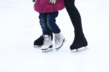 Naklejka premium the child and the man is skating on the ice rink