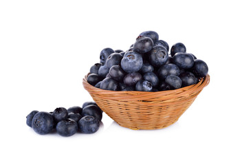 fresh blueberries in bamboo basket and on white background