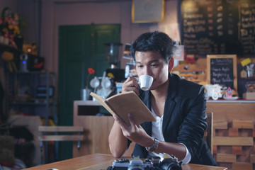 Tourists read a book and drink coffee and camera on the table in