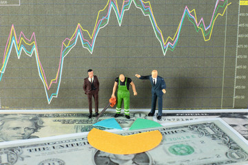 A sawyer is cutting the dividends for two business men. Conceptual image of dividends with stock chart and dollar background.