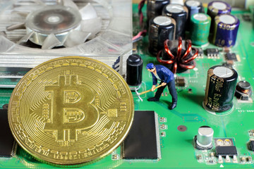 A little miner is digging on graphic card with golden coin. bitcoin mining and crypto currency concept.