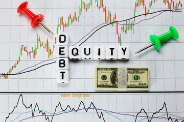 Debt and equity letter cube on white candle stick chart background. conceptual image for D/E ratio in stock investment.