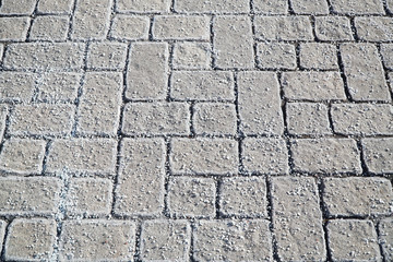 winter ice melting salt on the brick ground