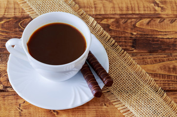 coffee cup and beans, cinnamon sticks, chocolate on wooden table background