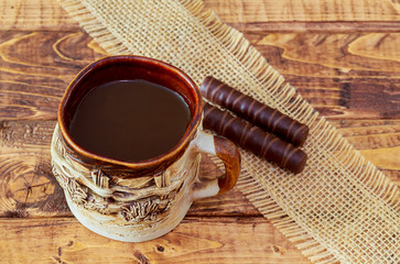 coffee cup and beans, cinnamon sticks, chocolate on wooden table background