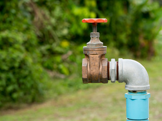 Close up old grunge brass faucet water in nature park background.