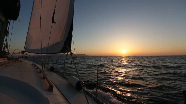 Sailing boat during amazing sunset on the sea.