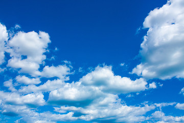 Naklejka na ściany i meble Blue sky background with clouds in bright sunny summer day.