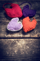 Valentine's Day. Colorful knitted hearts. Red heart on the dark old boards. Valentines day. Heart pendant. Red heart. Valentine cards. Eighth of March. International Women's Day. Toned image.