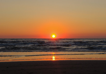 Fiery sunrise at Italian beach. Summer season. Emilia Romagna region. Adriatic sea. Italy