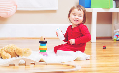 Happy toddler girl playing with her teddy bear