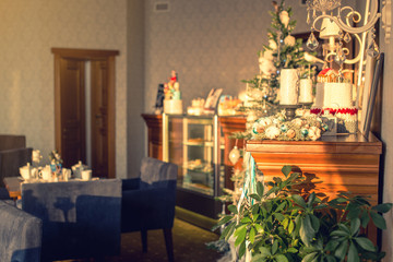 interior cozy cafe in eve of Christmas, decorated pine tree