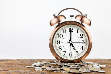Alarm clock and money coins stack