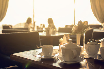 table with hot tea on a background of silhouettes girls