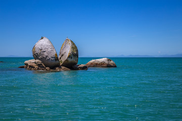 Split Apple rock landmark in landscape with blue ocean and clear sky, Abel Tasman New Zealand