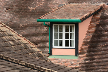 A dormer window on a tiles roof