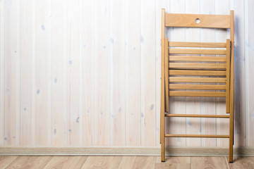 wooden folding chair near the wall, the left space