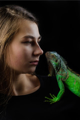 Perfect portrait beautiful girl and green iguana in the studio