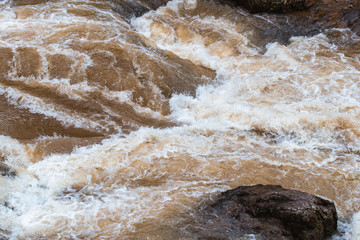 Mud water flow through rock river