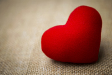 Valentine red heart on hessian background, selective focus