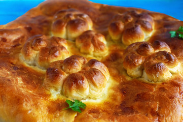 Homemade pie with cabbage close up on a blue background.
