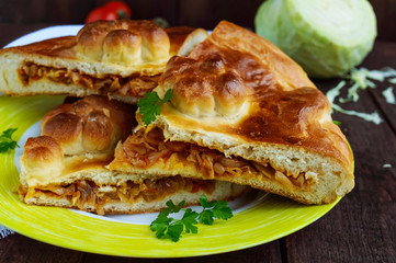 Homemade pie with cabbage chopped pieces on a blue background. The top view
