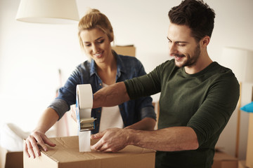 Man taping cardboard box to move .