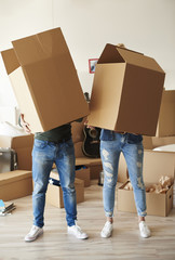 Fototapeta na wymiar Couple faces behind cardboard boxes .